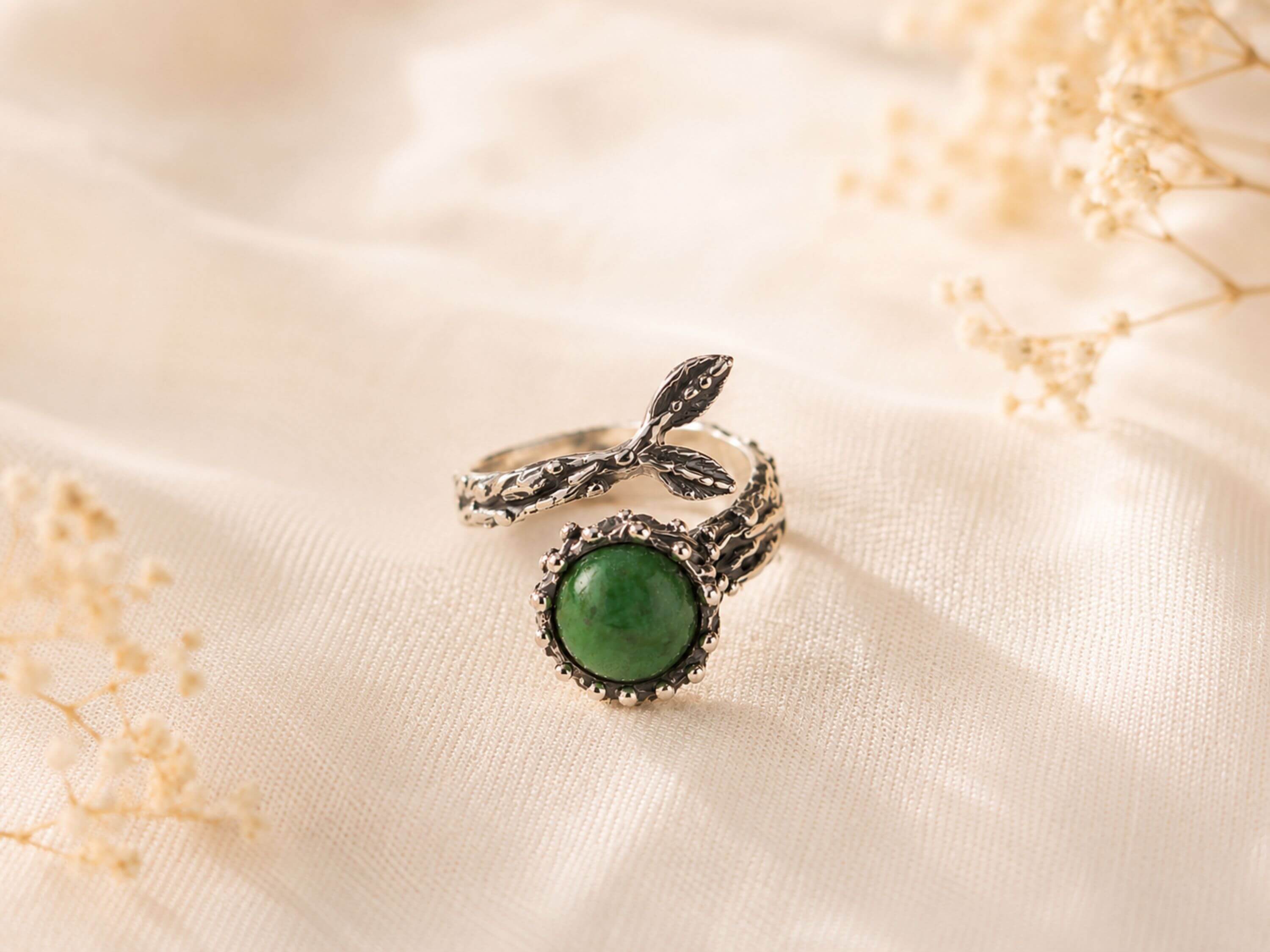 Handcrafted raw green Jade statement ring in a textured sterling silver setting, displayed on a neutral background.
