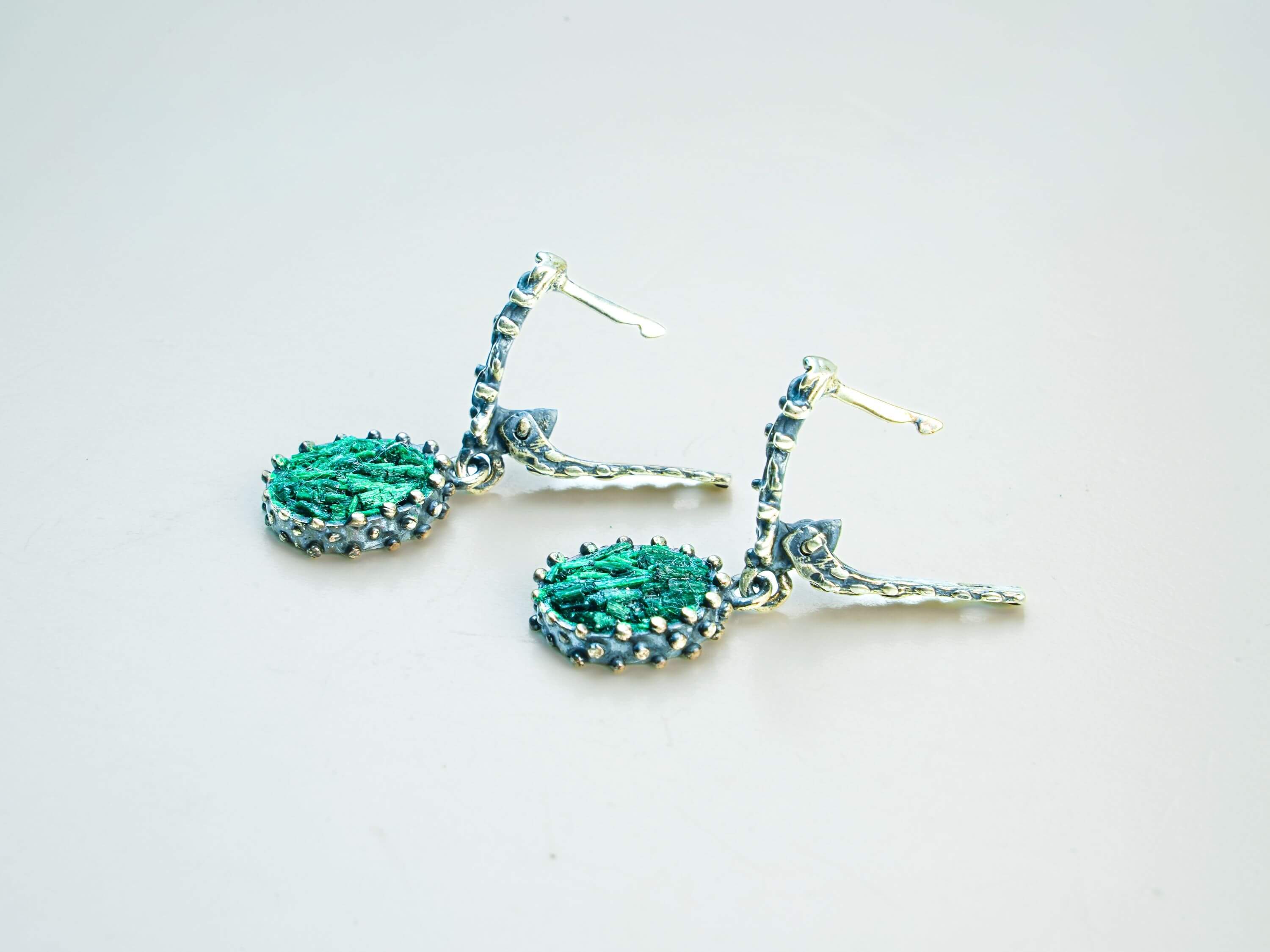 Detailed shot of the Malachite gemstone under soft light, capturing the natural luster and unique stone banding reflections