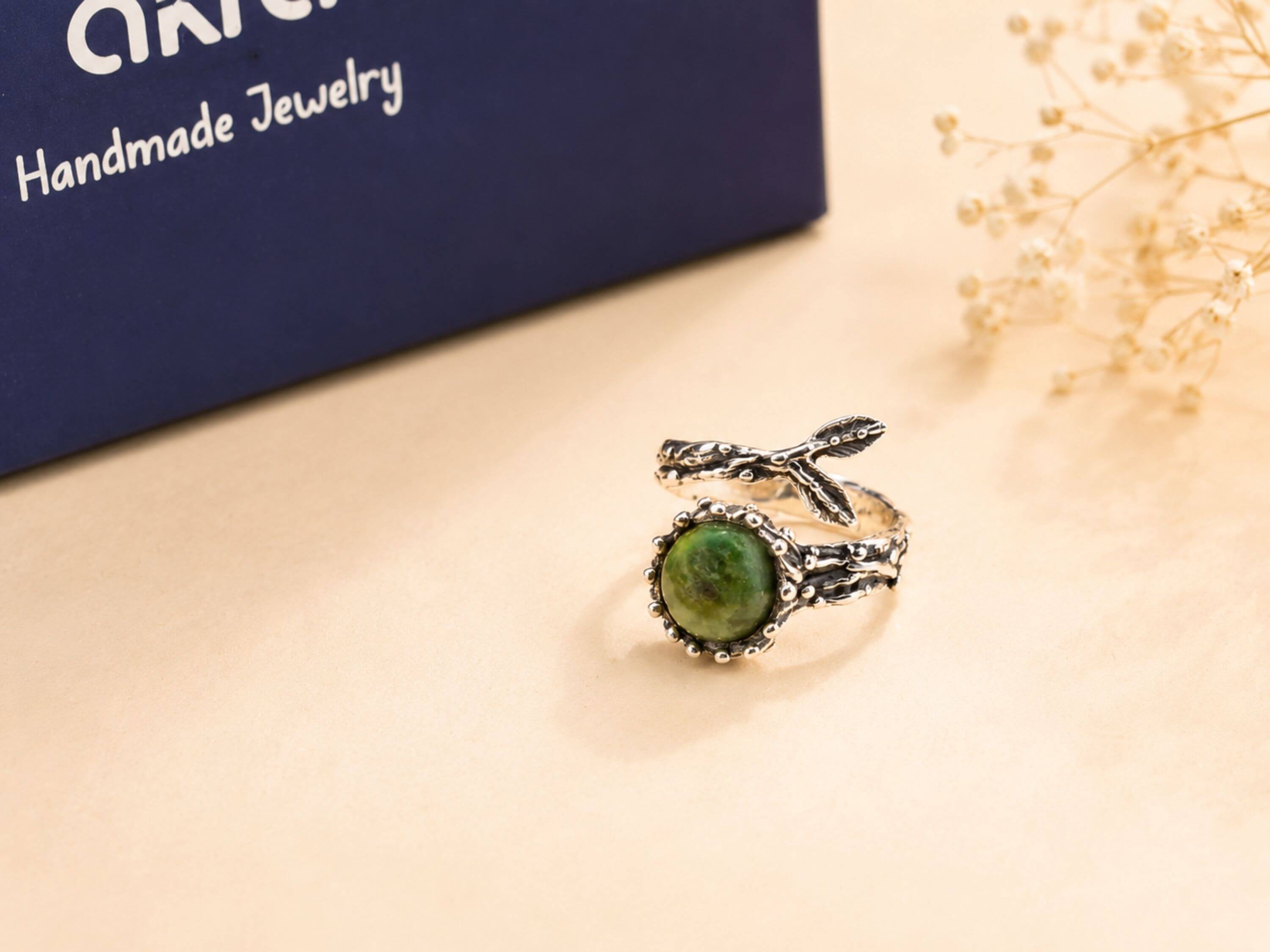 Detailed view of the unique silver 'claws' holding the raw Jade stone, highlighting the fusion of raw nature and bold jewelry design.
