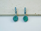 Vintage-style oval Malachite earrings in detailed sterling silver setting, showcasing natural green gemstone patterns on a soft beige background